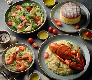 Un plato de ensalada, un plato de risotto de bogavante y un plato de bizcocho